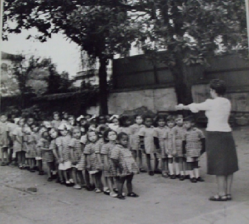Educadora ordenando as crianças em fila, no Dispensário Central da Cruzada Pró-Infância (Cruzada Pró-Infância, 1935) Educadora ordenando as crianças em fila, no Dispensário Central da Cruzada Pró-Infância (Cruzada Pró-Infância, 1935)