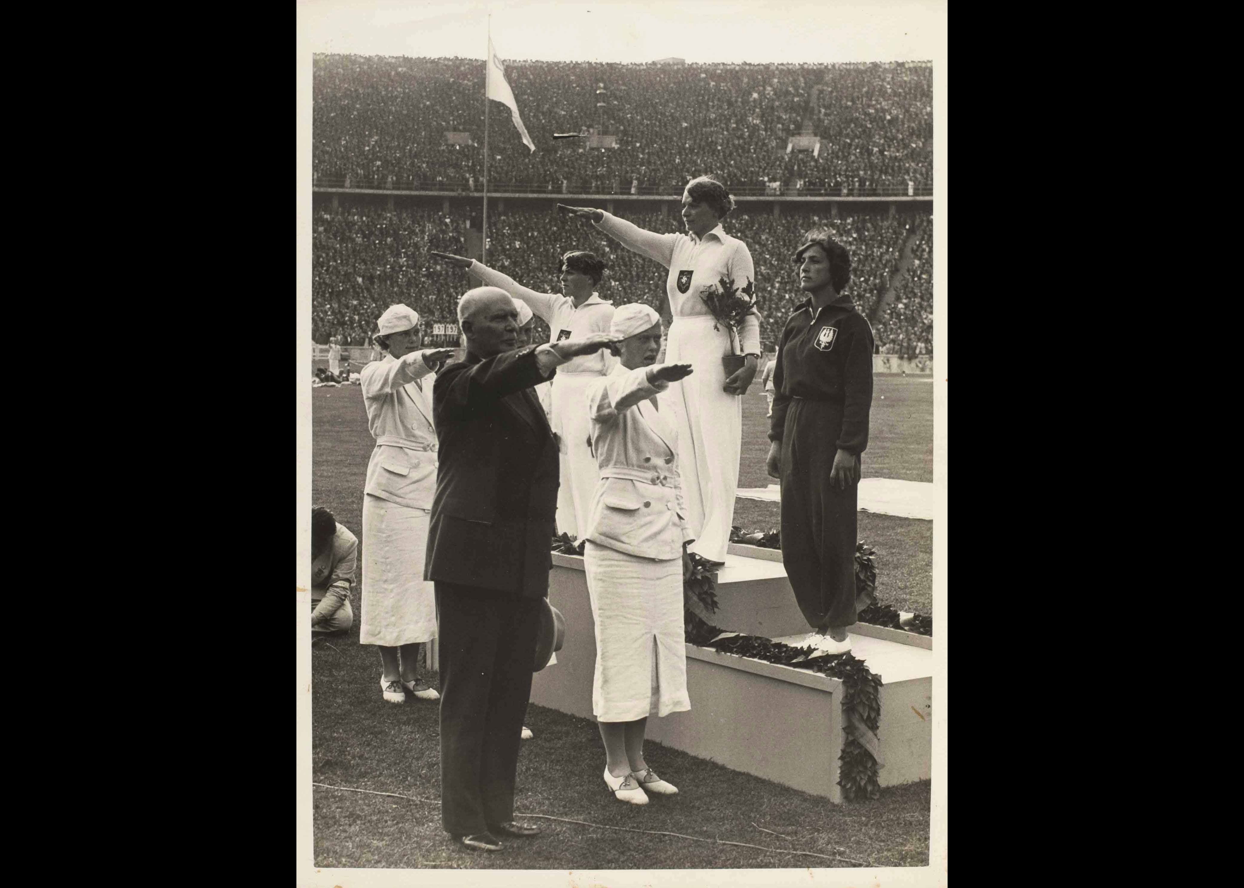 Tilly Fleisher, de Nuremberg, conquista em arremesso de dardo a primeira medalha de ouro da Allemanha. A homenagem para as arremessadoras. As vencedoras (da esquerda) Srta. Krüger (Allemanha), medalha de prata, Srta. Fleisher (Allemanha), medalha de ouro, e Srta. Kwasniewska (Polônia), medalha de bronze.