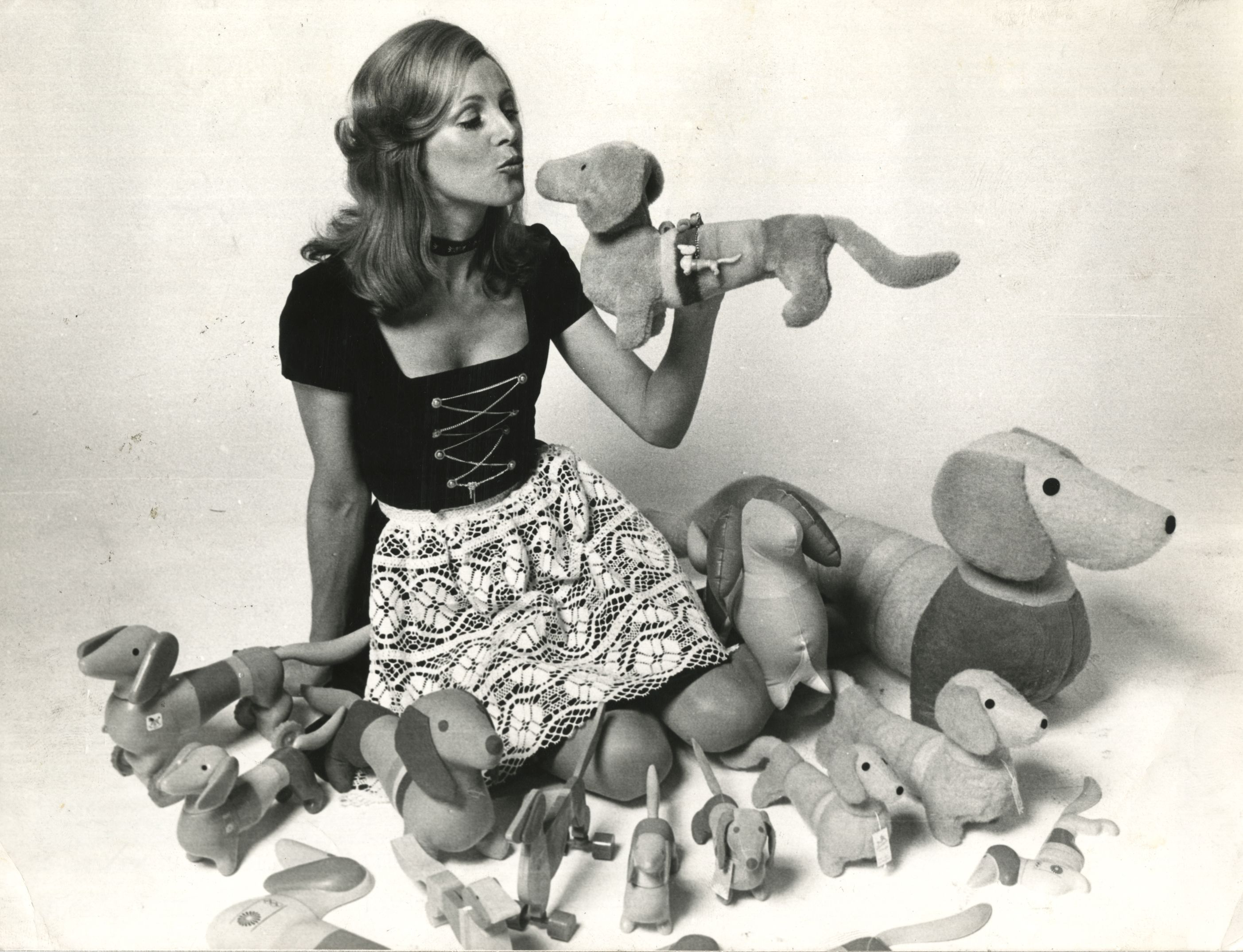 Eleita Miss Olimpíada-72, Uschi Bademberg (foto), diverte-se entre as réplicas do teckel Waldi, símbolo do certame deste ano.(...) Fabricado em plástico, madeira, toalharia turca ou pelúcia, ele foi inspirado na cadela Dackel, de pelo longo, que vive em Paris.